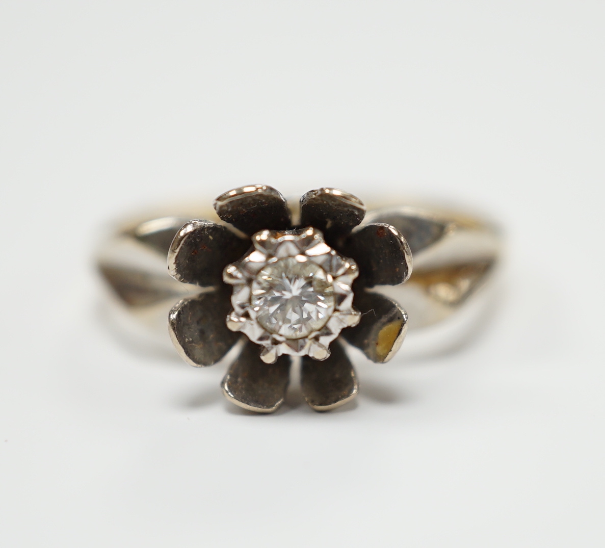 An 18ct gold and illusion set diamond flower head ring, size L, gross weight 4.7 grams.